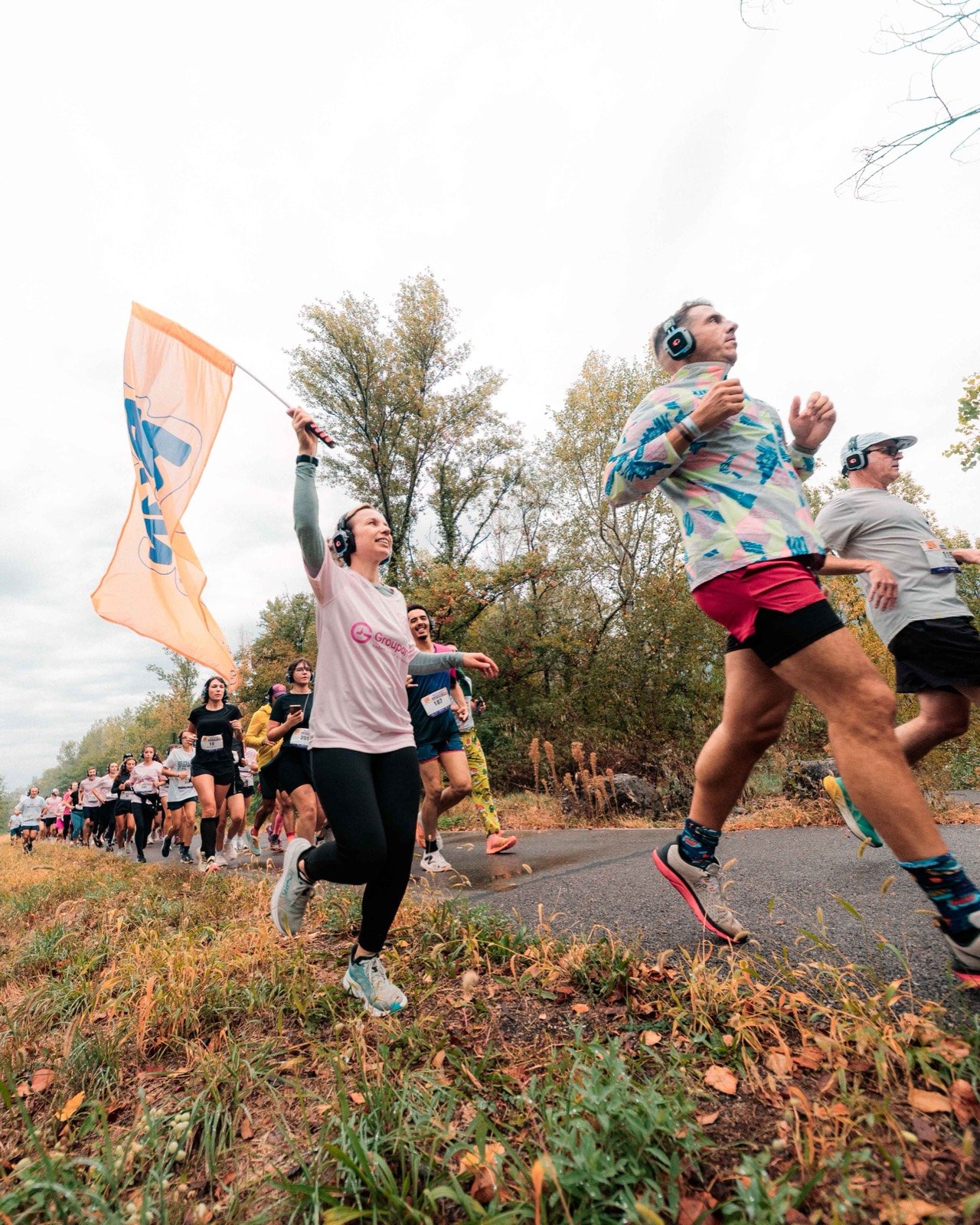 Une coureuse casquée brandit le drapeau RunRise pendant la course