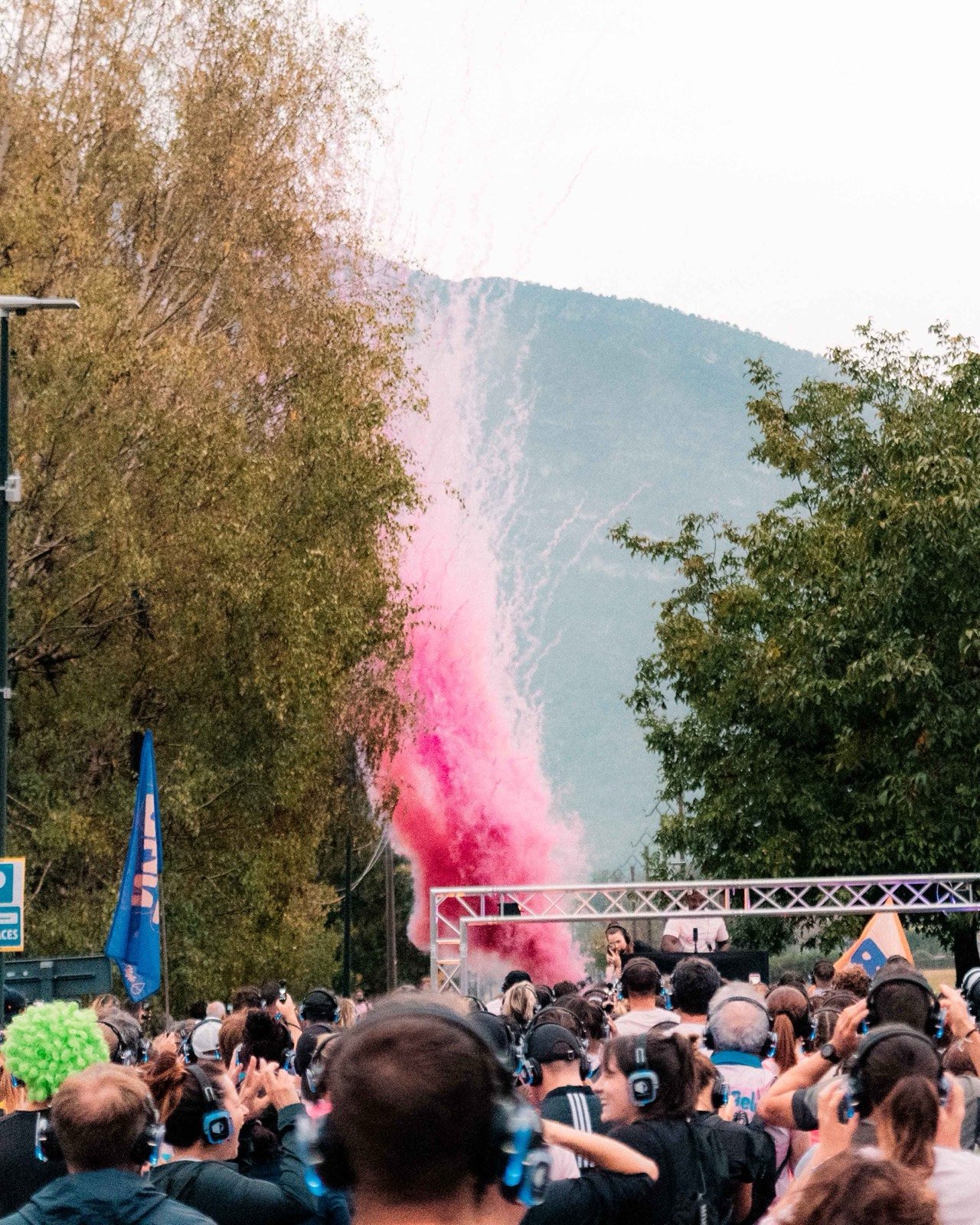 Fumigène rose au-dessus des coureurs casqués sur la ligne de départ