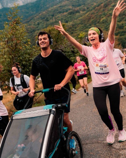 Un coureur pousse une poussette, une coureuse salue